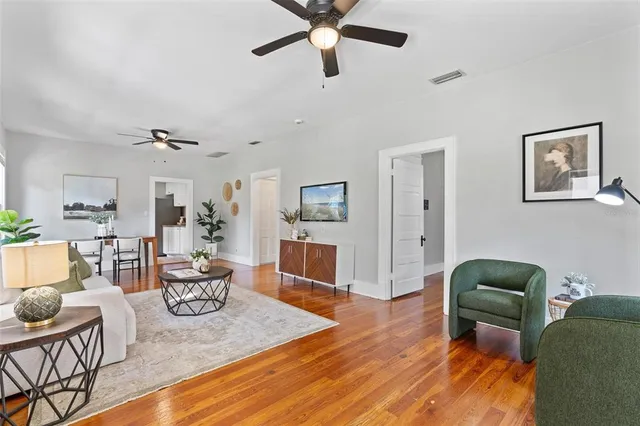 a living room with furniture and a wooden floor