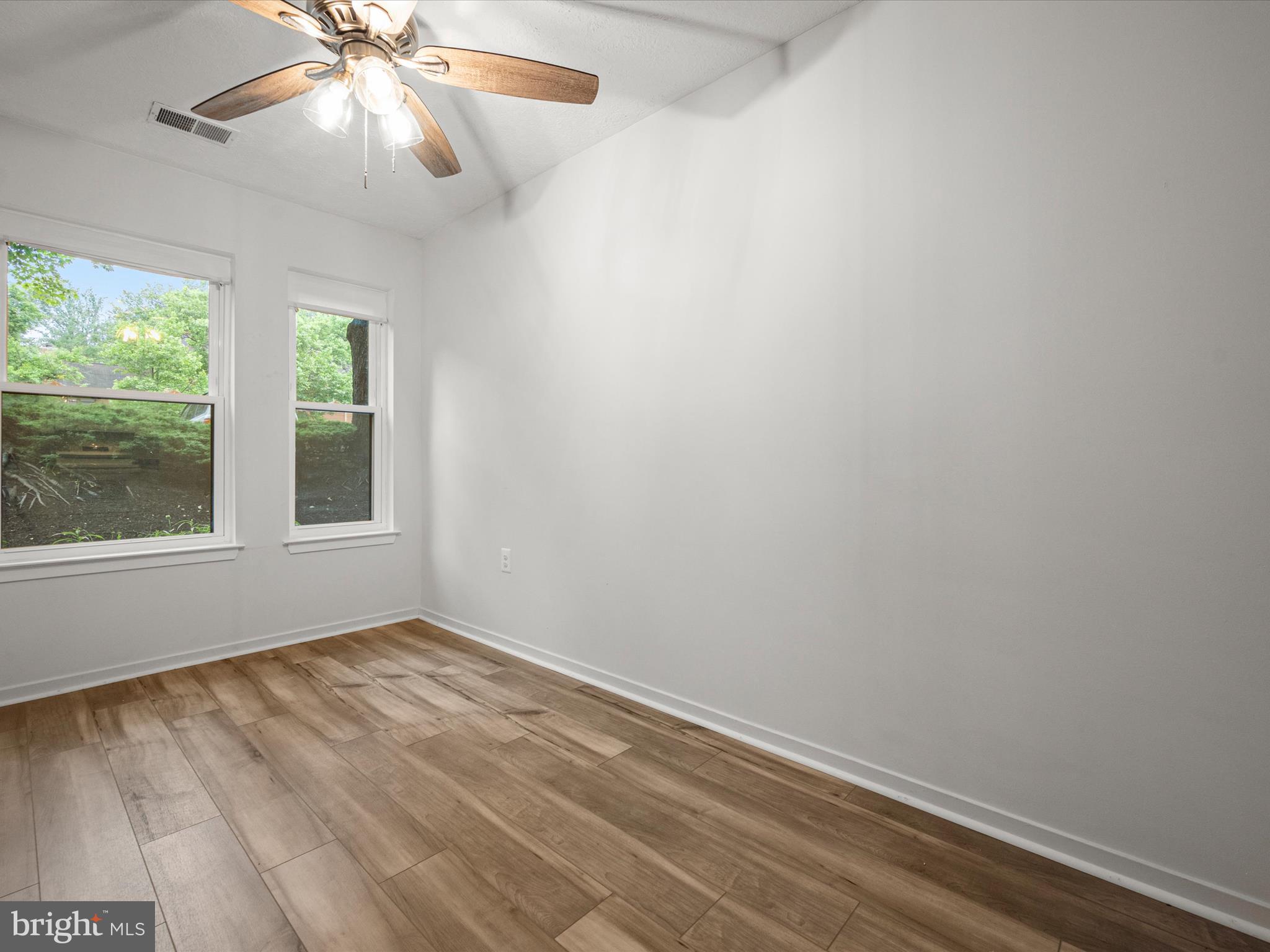 7607 Weather Worn Way, Unit A Columbia, MD 21046 - Photo 13 of 36 a view of an empty room with wooden floor and a window