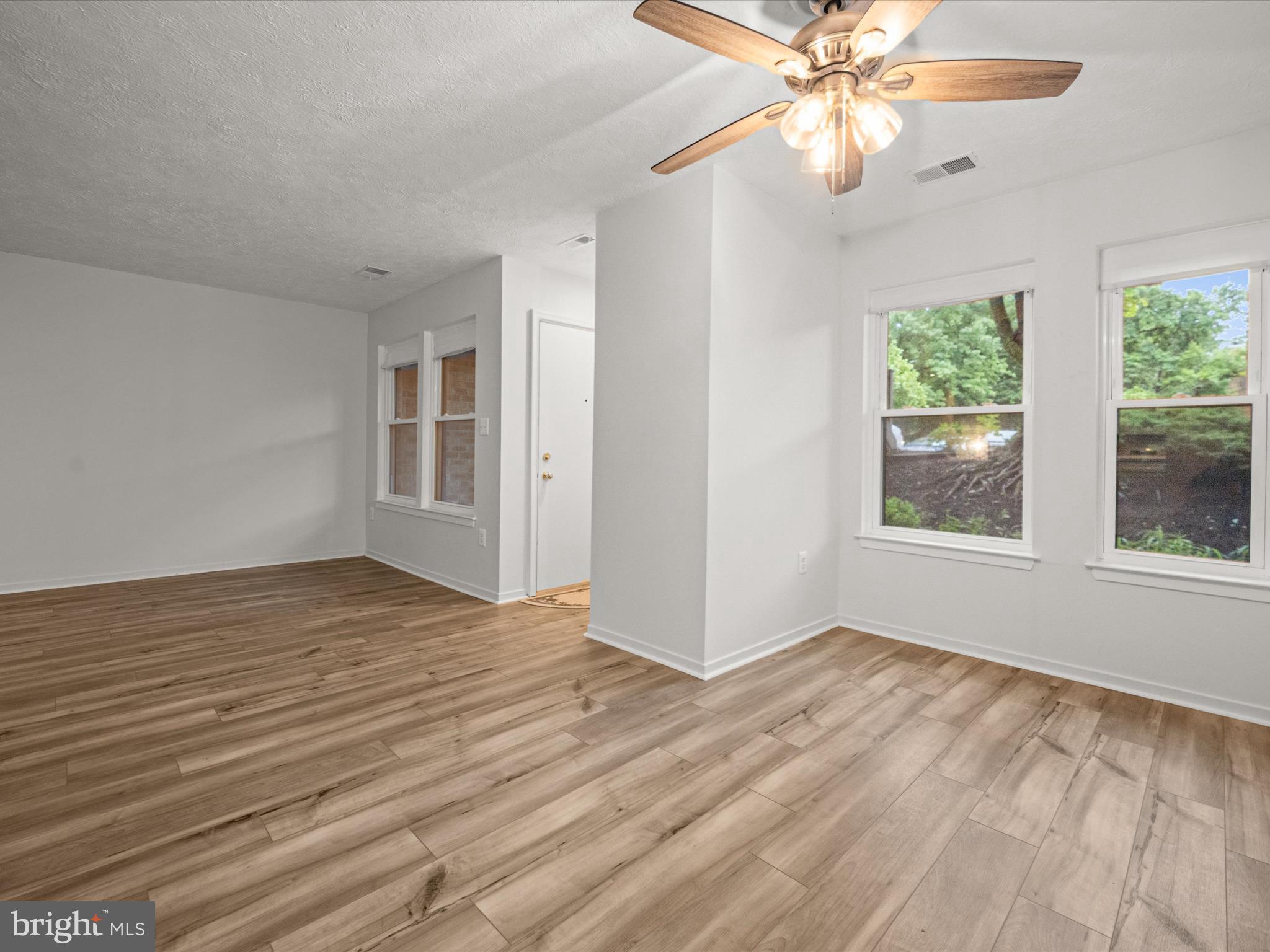 7607 Weather Worn Way, Unit A Columbia, MD 21046 - Photo 14 of 36 a view of an empty room with wooden floor and a window