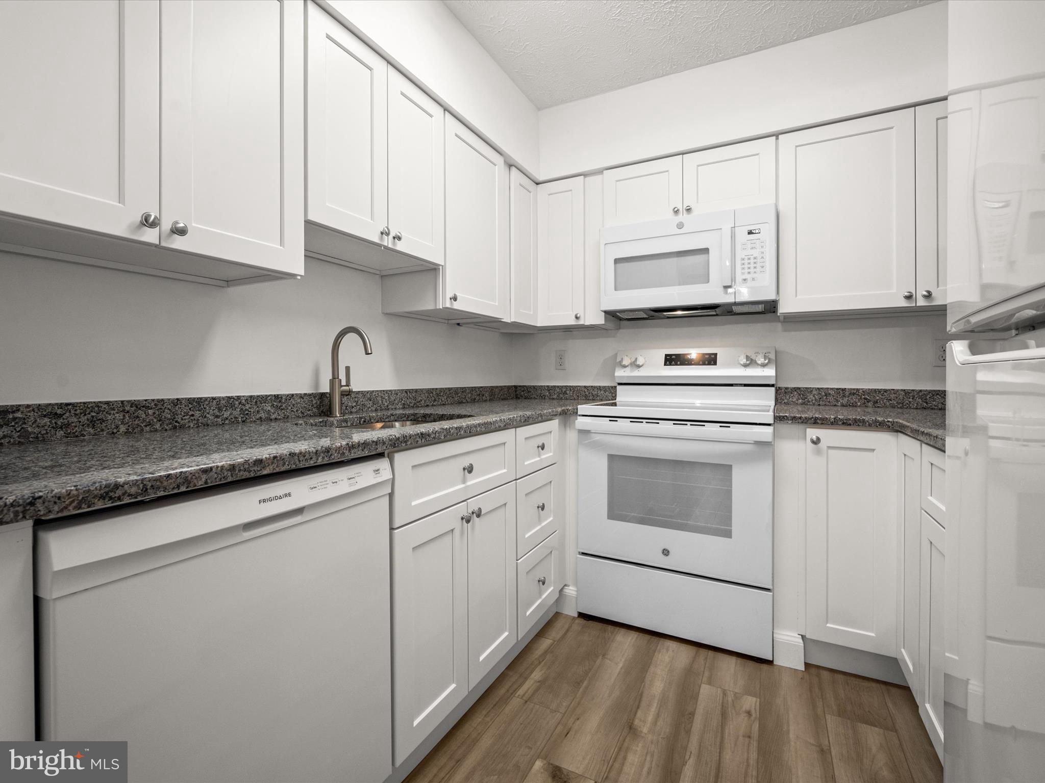 7607 Weather Worn Way, Unit A Columbia, MD 21046 - Photo 16 of 36 a kitchen with cabinets appliances a sink and a counter top