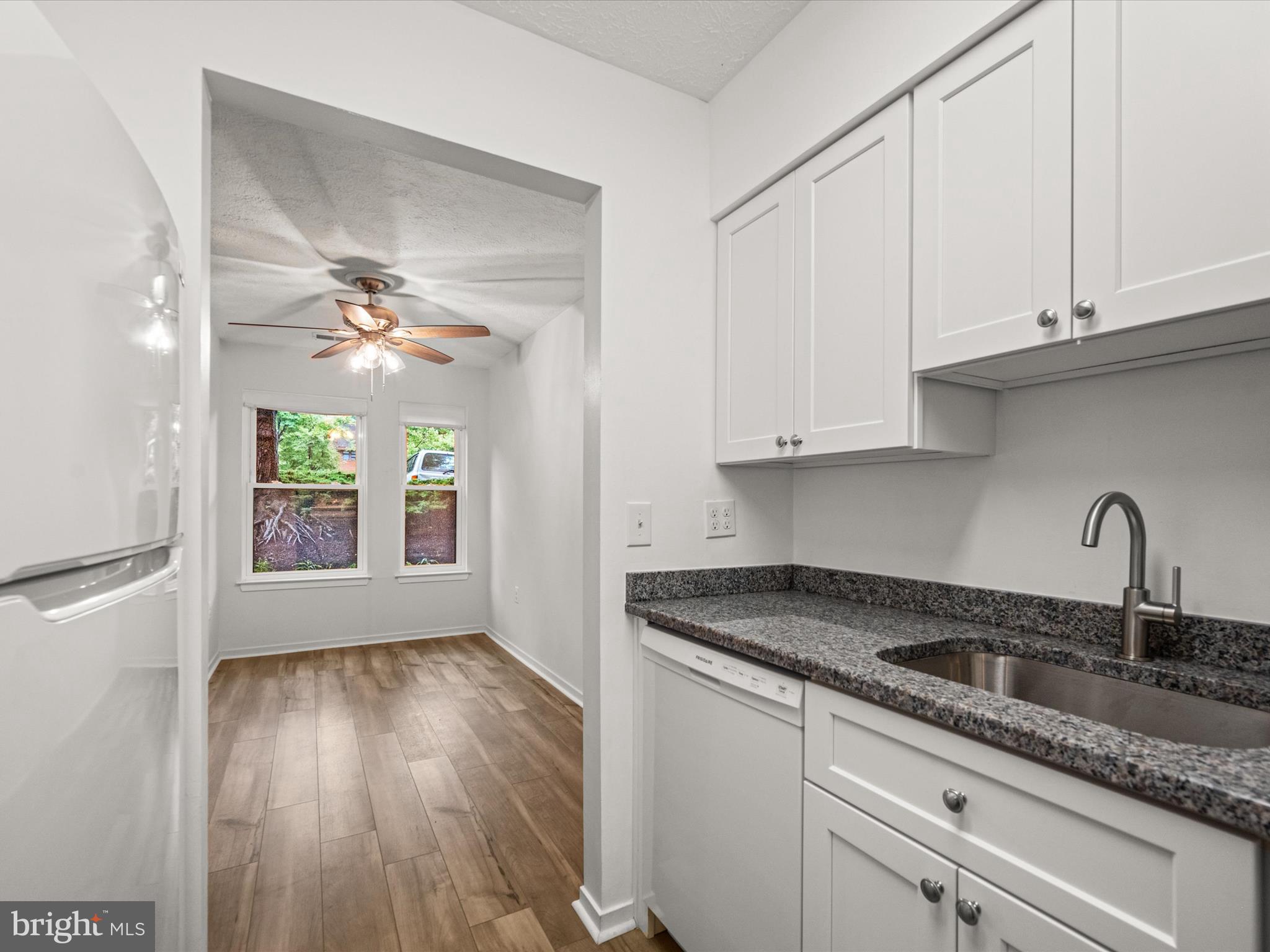 7607 Weather Worn Way, Unit A Columbia, MD 21046 - Photo 18 of 36 a kitchen with granite countertop a sink cabinets and window