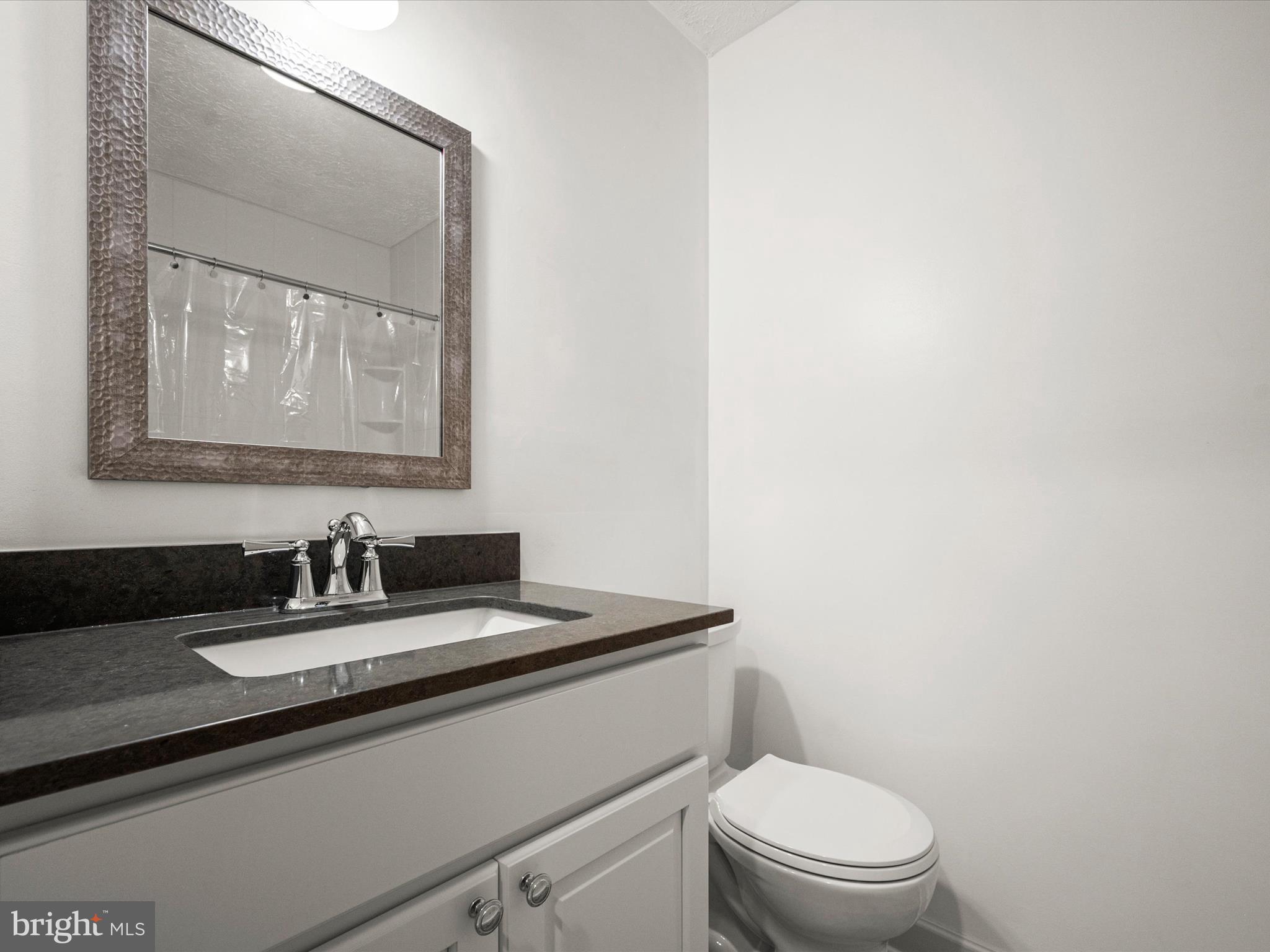 7607 Weather Worn Way, Unit A Columbia, MD 21046 - Photo 26 of 36 a bathroom with a toilet a sink and mirror