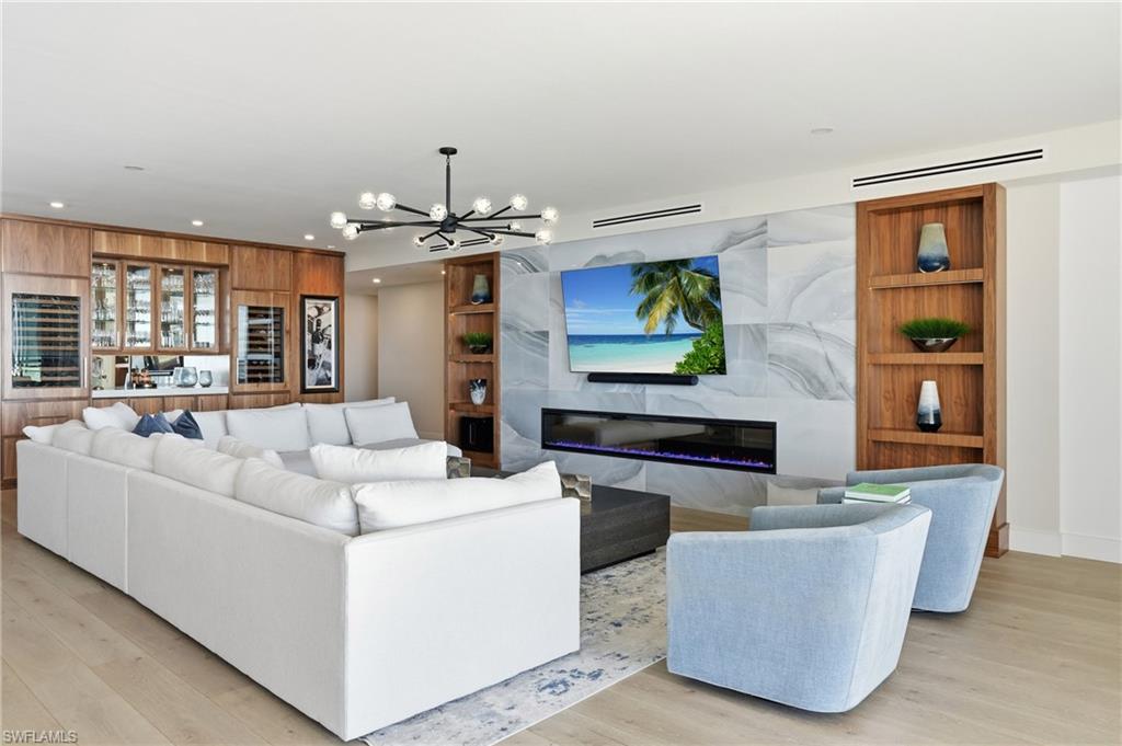 13945 Old Coast Road, Unit 1906 Naples, FL 34110 - Photo 1 of 40 a living room with furniture and a flat screen tv