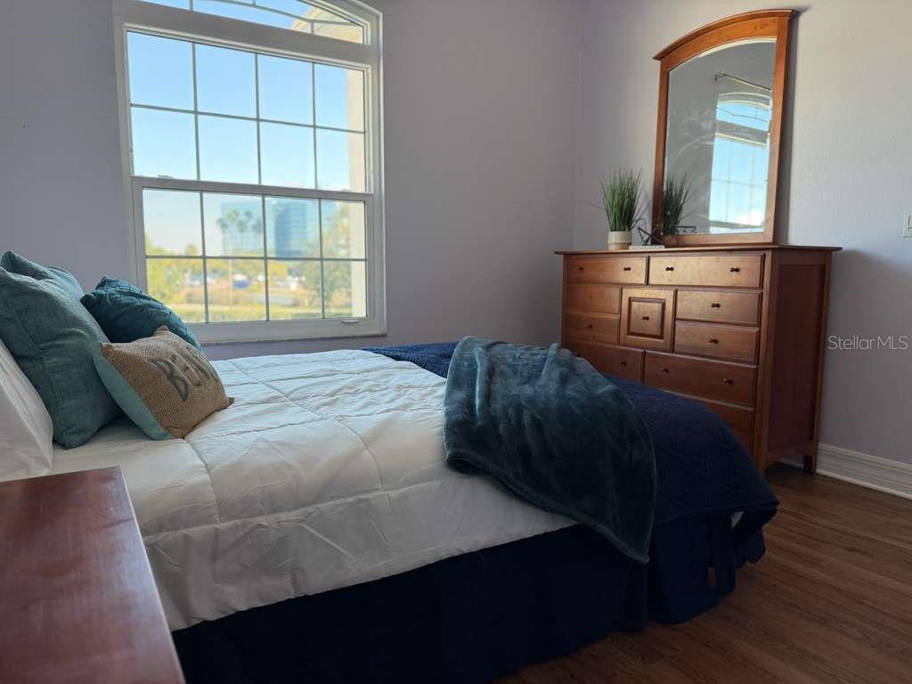 13606 Eagles Walk Drive Clearwater, FL 33762 - Photo 14 of 28 a bedroom with a bed next to a window with wooden floor