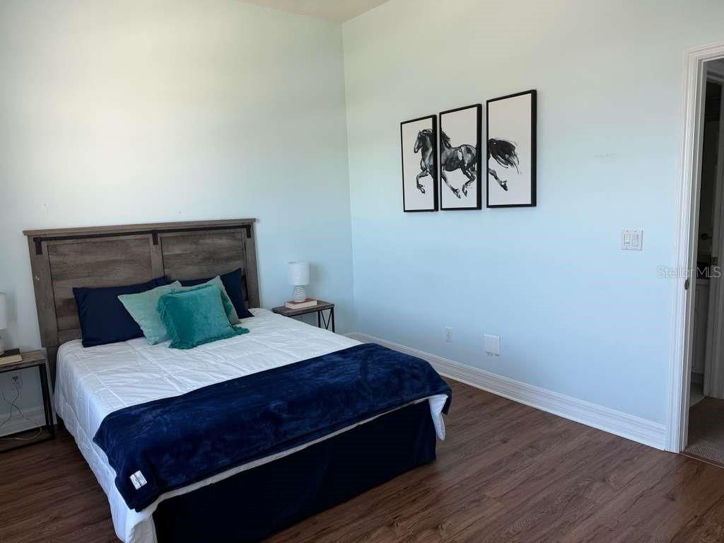 13606 Eagles Walk Drive Clearwater, FL 33762 - Photo 17 of 28 a bed sitting in a bedroom next to a wall with wooden floor