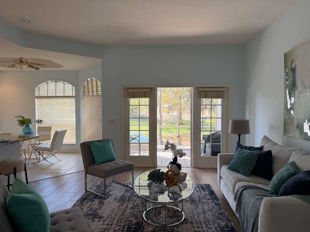 13606 Eagles Walk Drive Clearwater, FL 33762 - Photo 6 of 28 a living room with furniture a fireplace and large windows