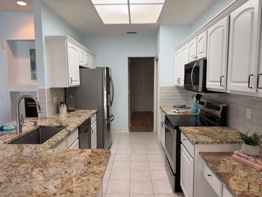 13606 Eagles Walk Drive Clearwater, FL 33762 - Photo 7 of 28 a kitchen with stainless steel appliances granite countertop a refrigerator stove and sink