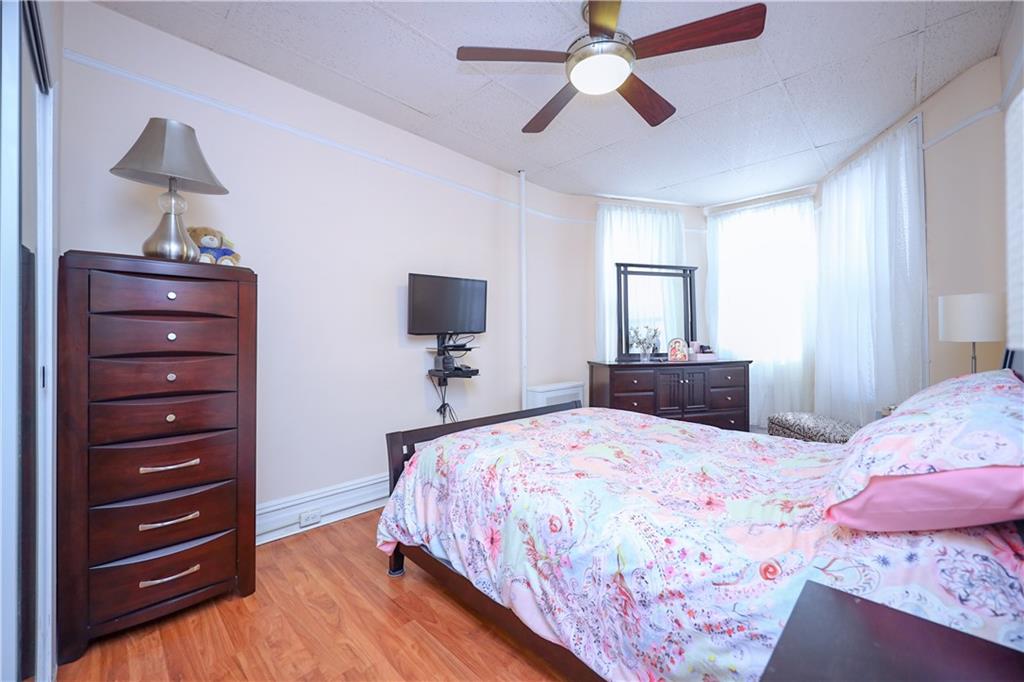578 Ovington Avenue Brooklyn, NY 11209 - Photo 13 of 40 a bedroom with a bed and a chandelier