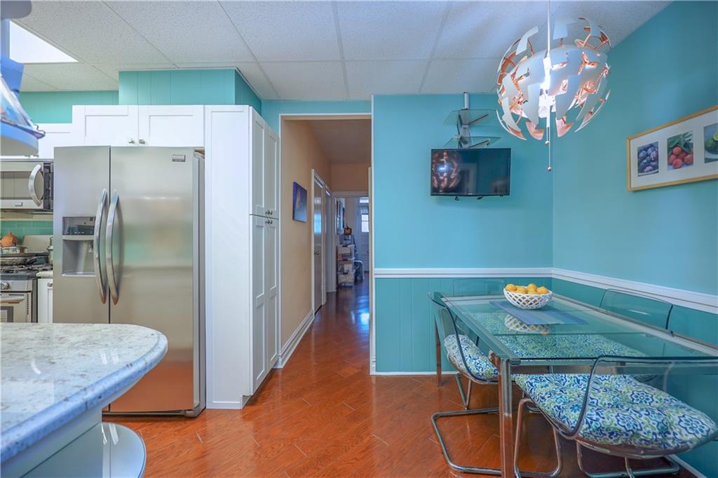 578 Ovington Avenue Brooklyn, NY 11209 - Photo 10 of 40 a kitchen with stainless steel appliances granite countertop a dining table chairs and chandelier