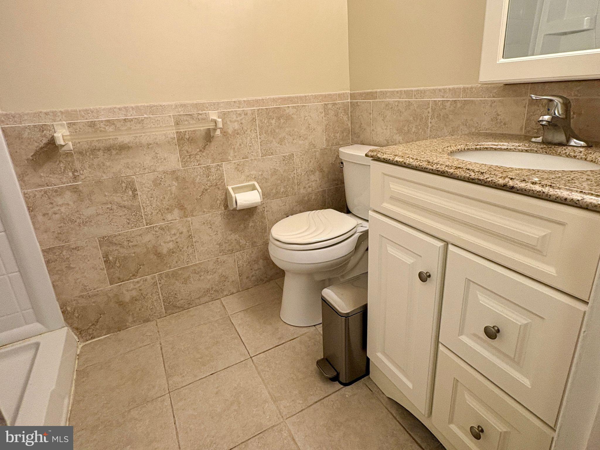 7 Rockford Road, Unit F1 Wilmington, DE 19806 - Photo 12 of 16 a bathroom with a granite countertop toilet and a sink