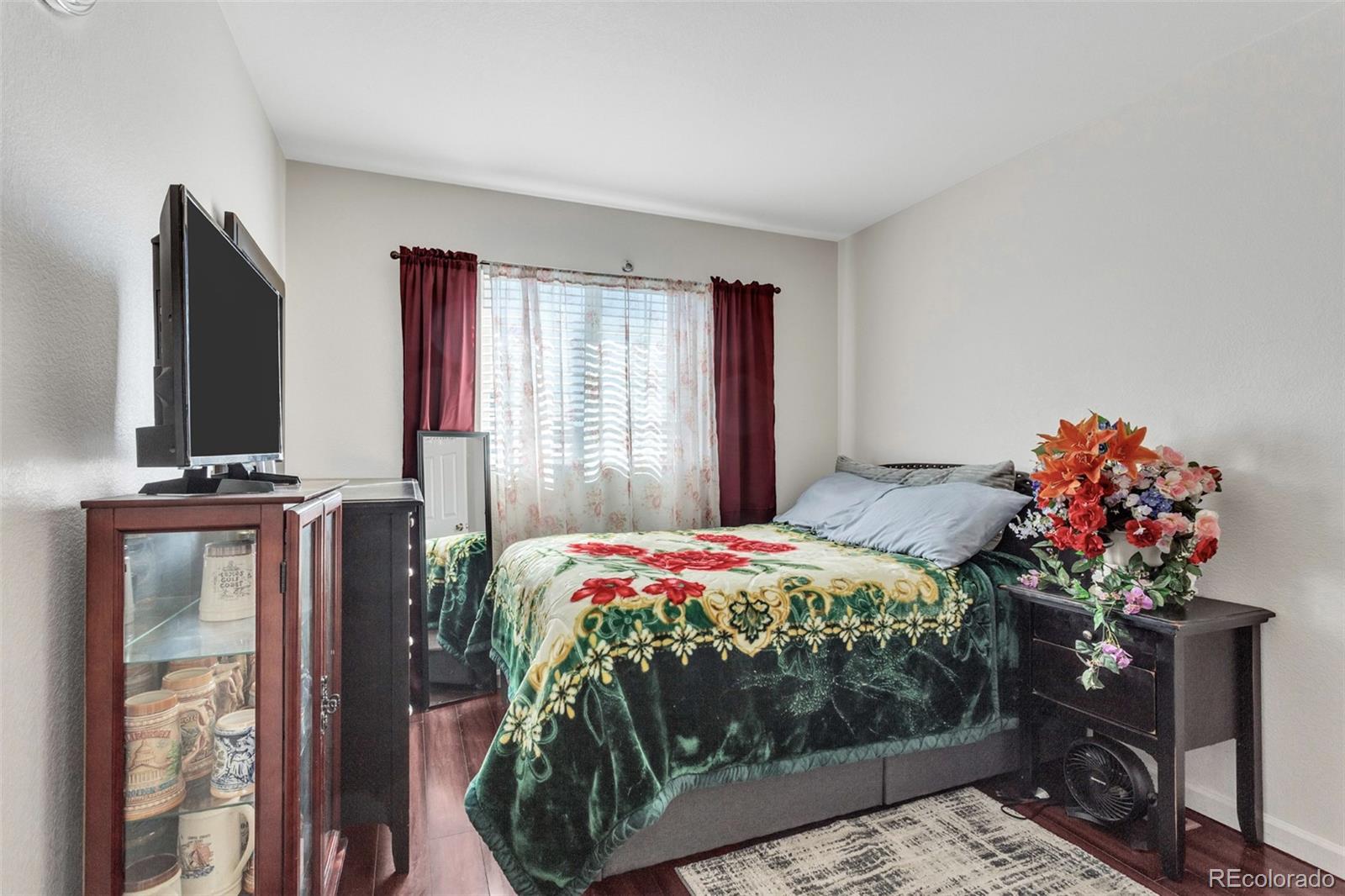 2645 South Danube Way Aurora, CO 80013 - Photo 12 of 24 a bedroom with a bed potted plant on dresser and a window