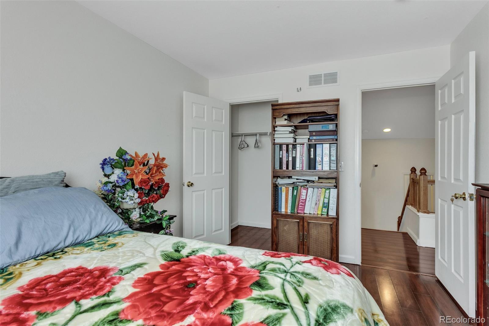 2645 South Danube Way Aurora, CO 80013 - Photo 13 of 24 a bedroom with a bed furniture and a book shelf