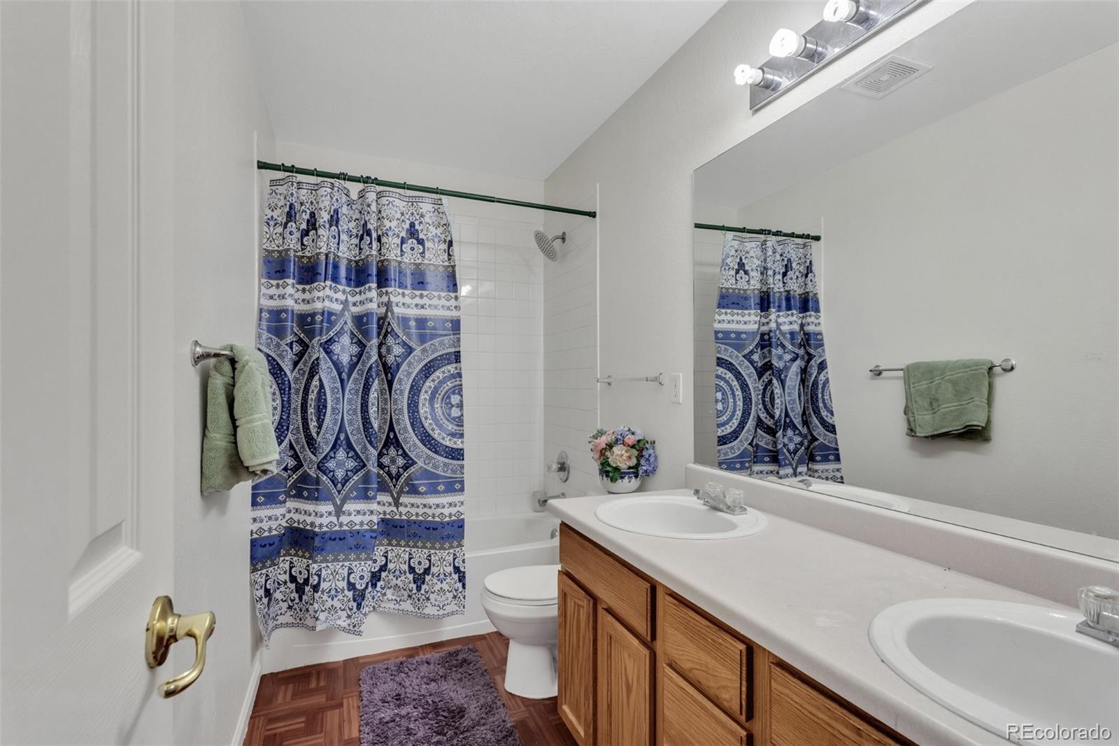 2645 South Danube Way Aurora, CO 80013 - Photo 16 of 24 a bathroom with a sink vanity mirror and shower