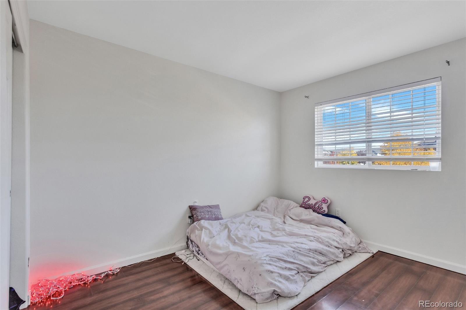 2645 South Danube Way Aurora, CO 80013 - Photo 17 of 24 a bedroom with a bed and wooden floor