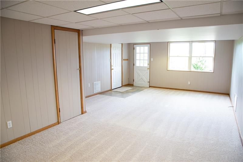 2323 Mill Grove Road Pittsburgh, PA 15241 - Photo 22 of 25 Lower level finished game room/ family room/ man cave. The closet door to the left has shelving for extra storage. White door on left leads into the 2 car garage.