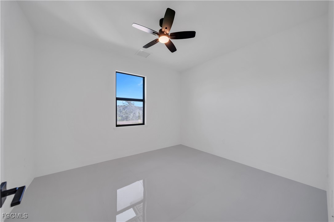 1112 Eisenhower Boulevard Lehigh Acres, FL 33974 - Photo 18 of 35 an empty room with a ceiling fan and window