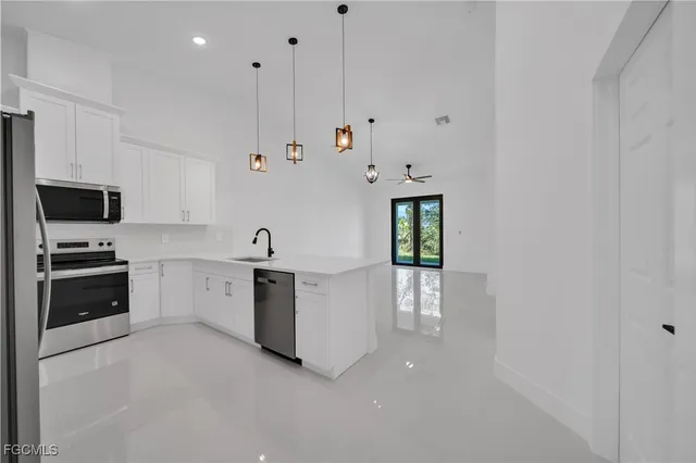 a large white kitchen with stainless steel appliances