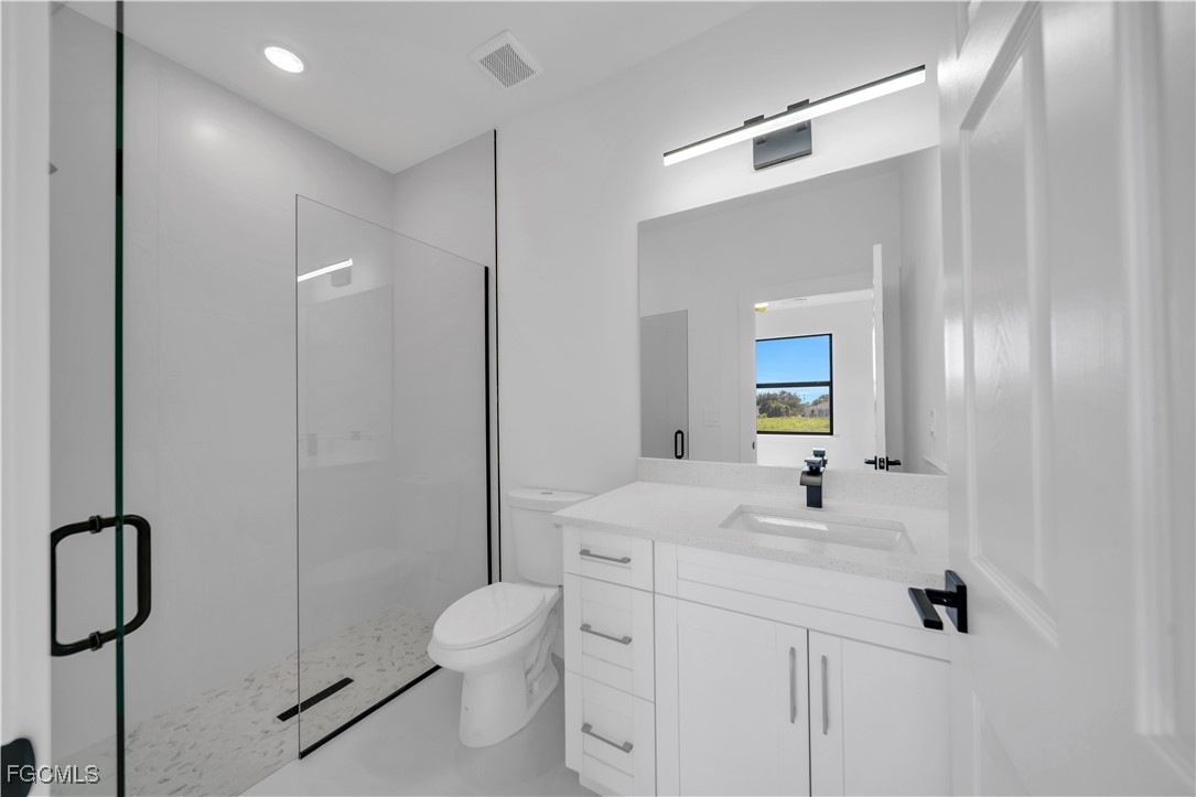 1112 Eisenhower Boulevard Lehigh Acres, FL 33974 - Photo 21 of 35 a bathroom with a sink a toilet and shower