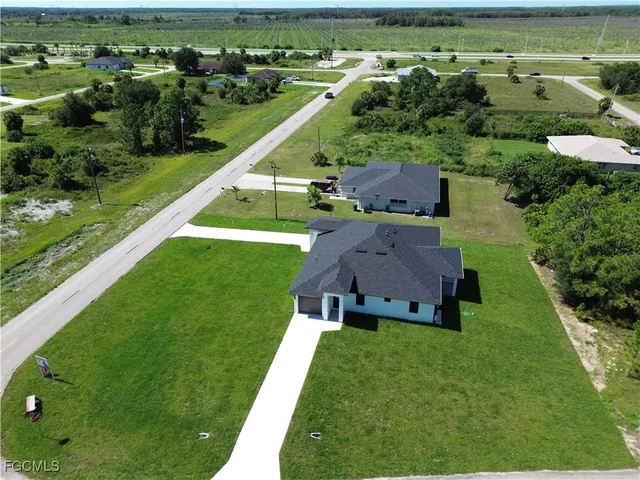 an aerial view of a residential house with a yard
