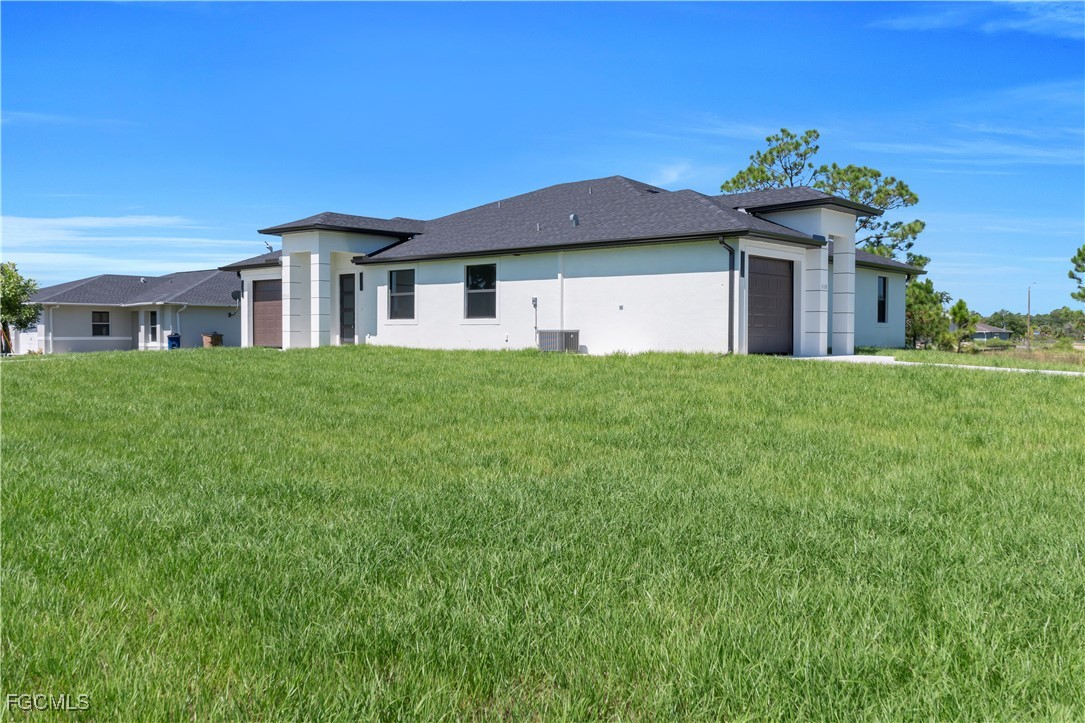 1112 Eisenhower Boulevard Lehigh Acres, FL 33974 - Photo 5 of 35 a house view with a garden space