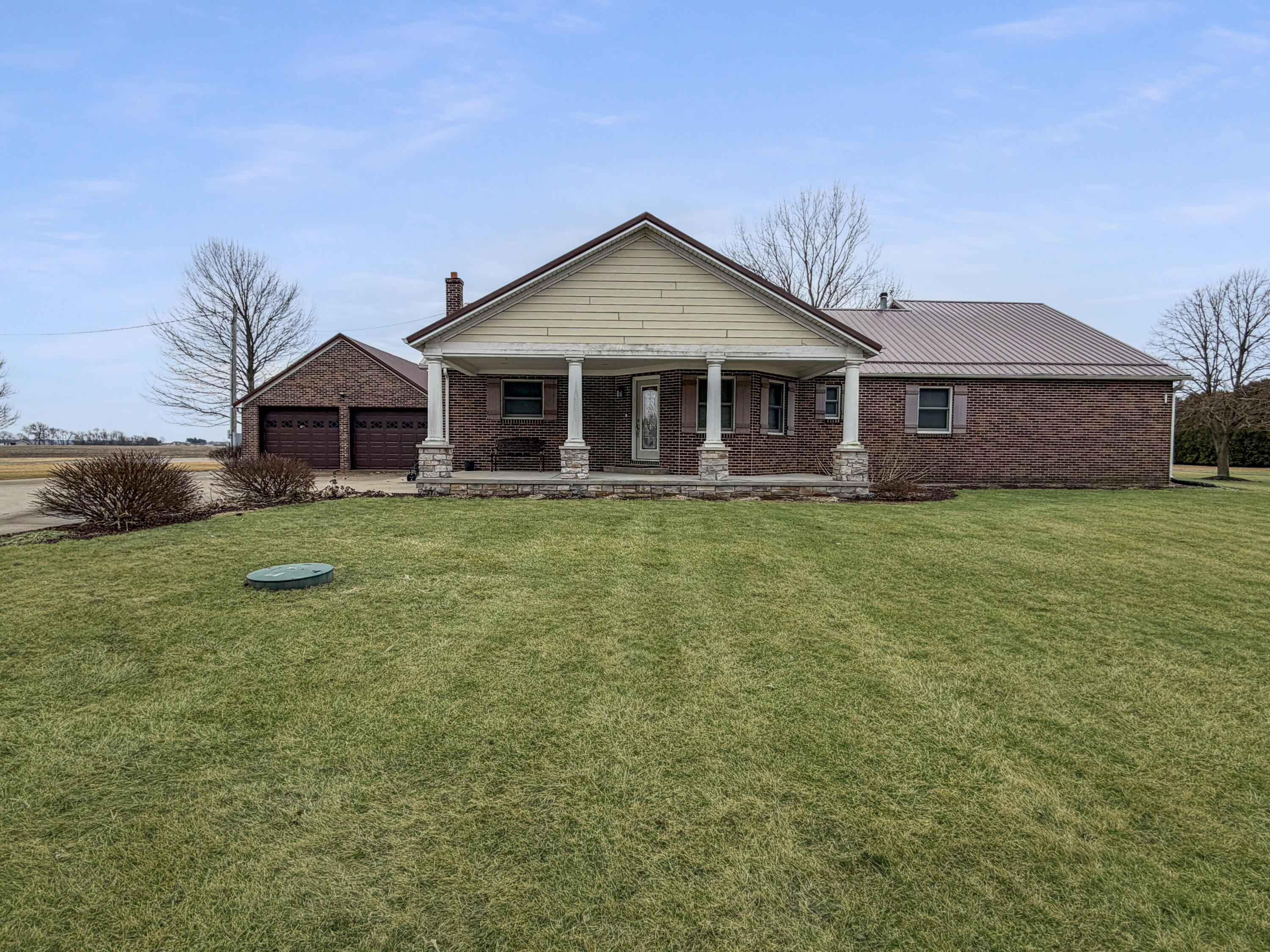 a view of a house next to a big yard and large trees