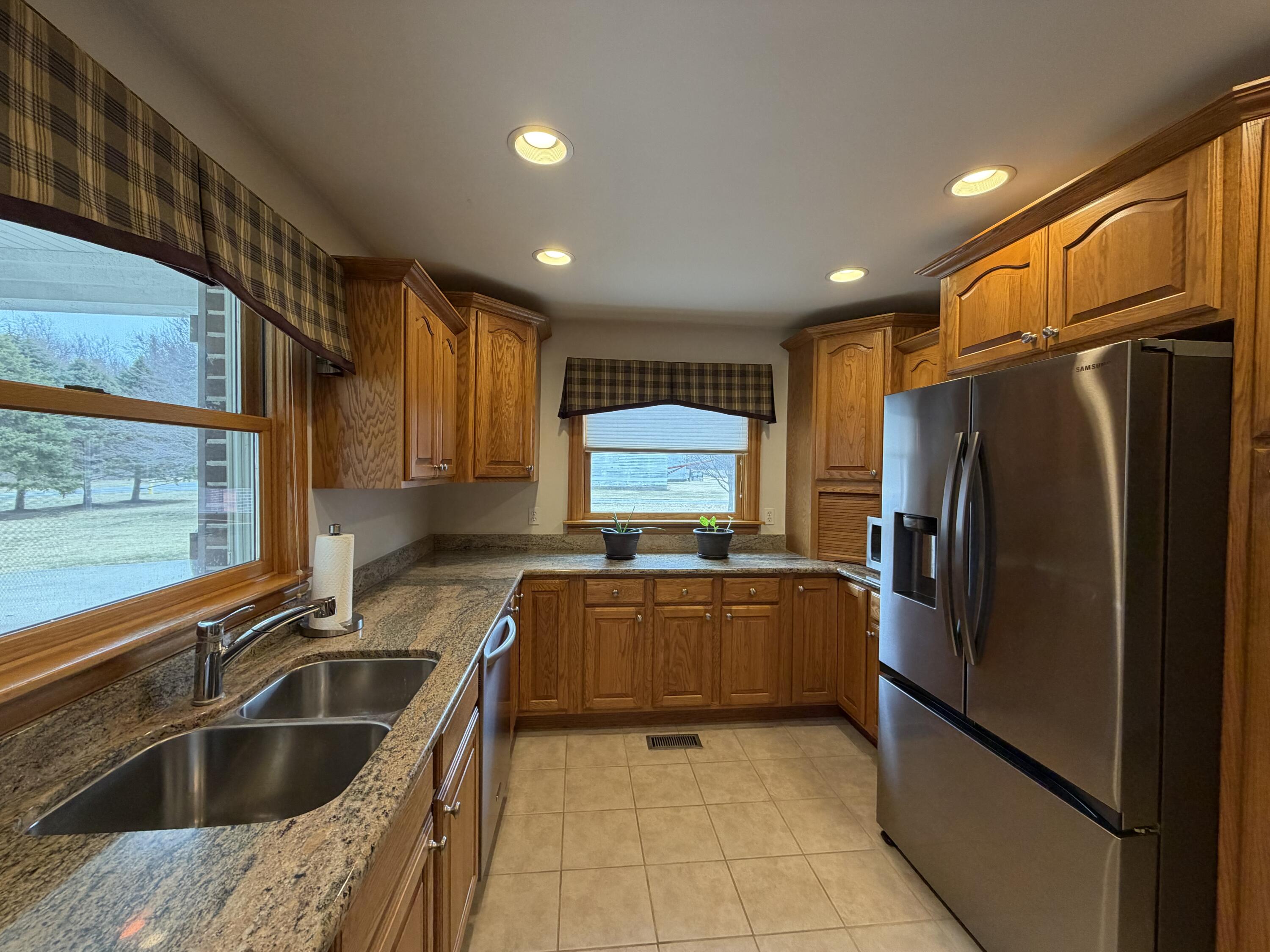 1245 West Mt Calvary Road Rensselaer, IN 47978 - Photo 13 of 35 a kitchen with granite countertop a refrigerator and a sink