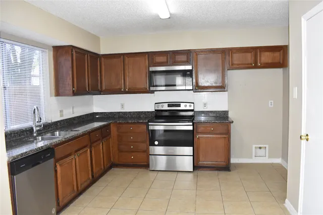 a kitchen with stainless steel appliances granite countertop a refrigerator and a sink