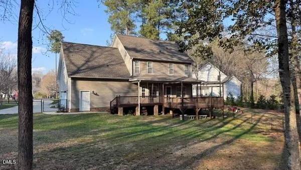 a view of a big house with a big yard and large trees