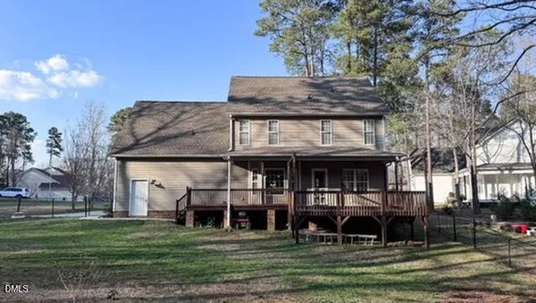 a view of a big house with a big yard and large trees