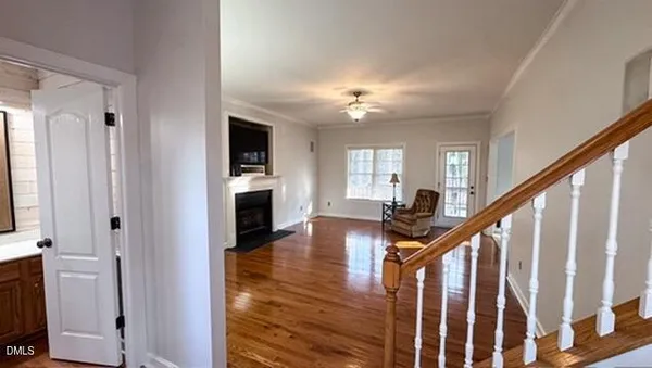 a view of a livingroom with wooden floor and stairs