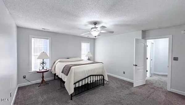 a spacious bedroom with a bed and a chandelier