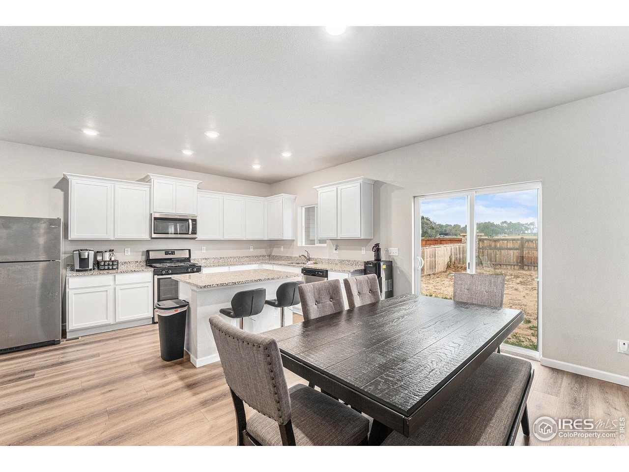 971 Ouzel Falls Road Severance, CO 80550 - Photo 5 of 16 a kitchen with a dining table chairs and wooden floor