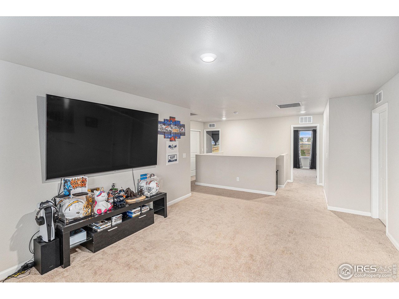 971 Ouzel Falls Road Severance, CO 80550 - Photo 9 of 16 a living room with a flat screen tv and gym equipment