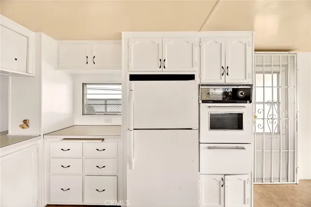 a kitchen with white cabinets and white appliances