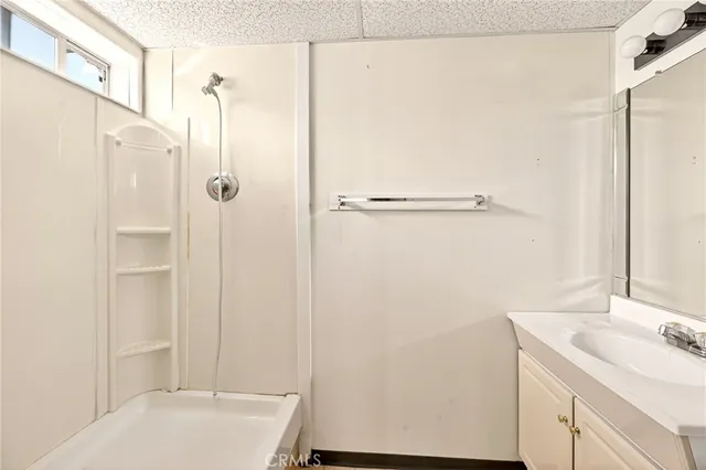 a bathroom with a sink mirror and a shower