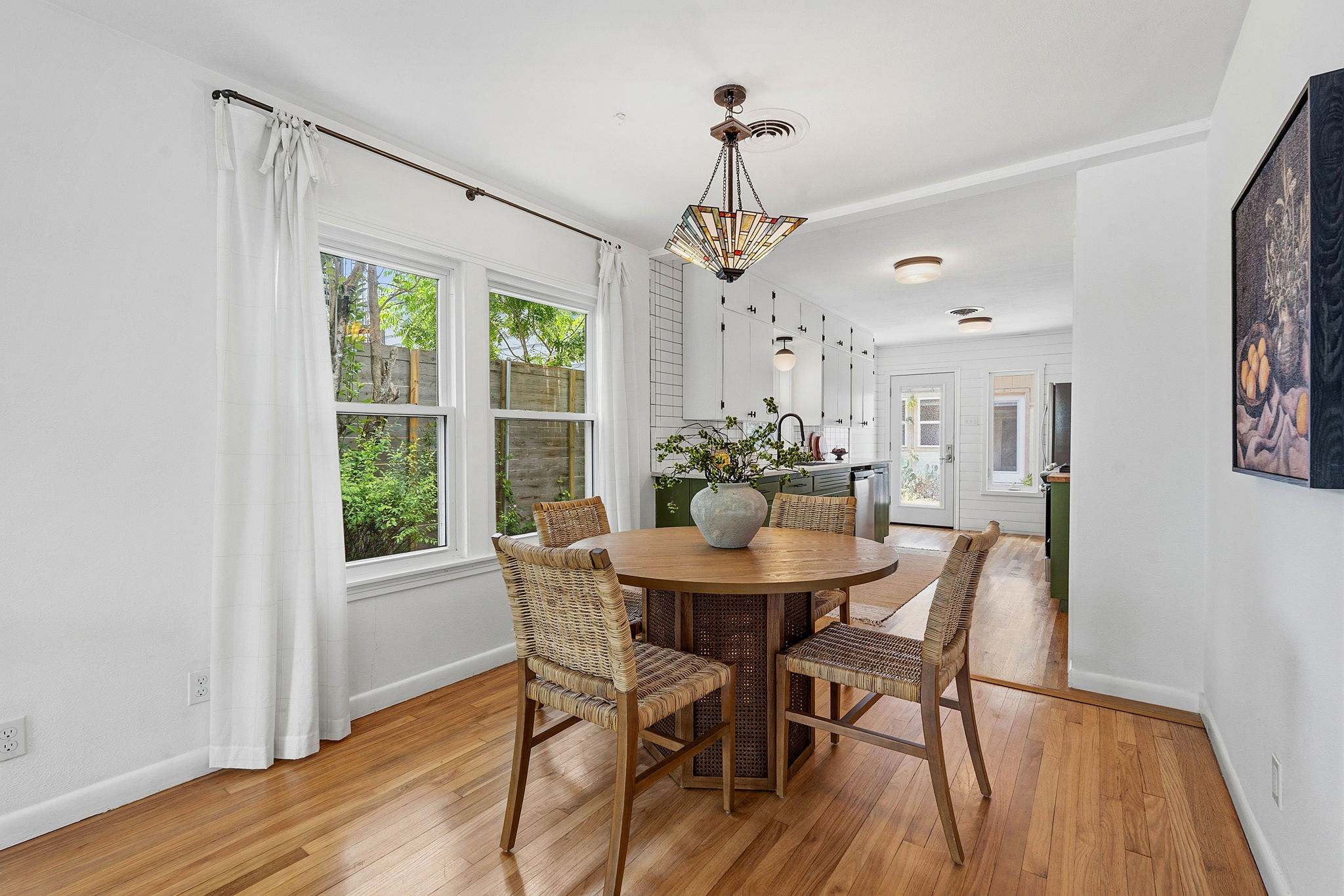900 Stark Street Austin, TX 78756 - Photo 6 of 25 Sun-drenched dining area with hardwood floors, seamlessly connecting to a modern kitchen.