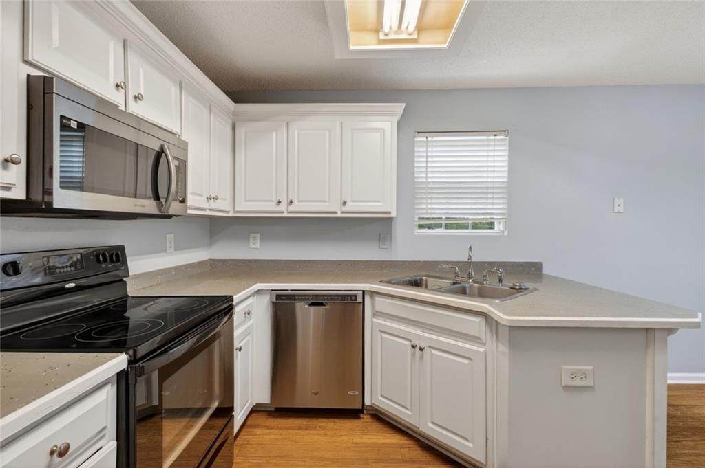 466 Raymond Drive Winder, GA 30680 - Photo 13 of 33 a kitchen with white cabinets stainless steel appliances and sink