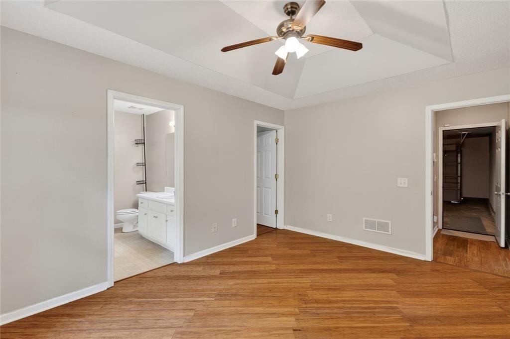 466 Raymond Drive Winder, GA 30680 - Photo 17 of 33 an empty room with wooden floor chandelier fan and entryway