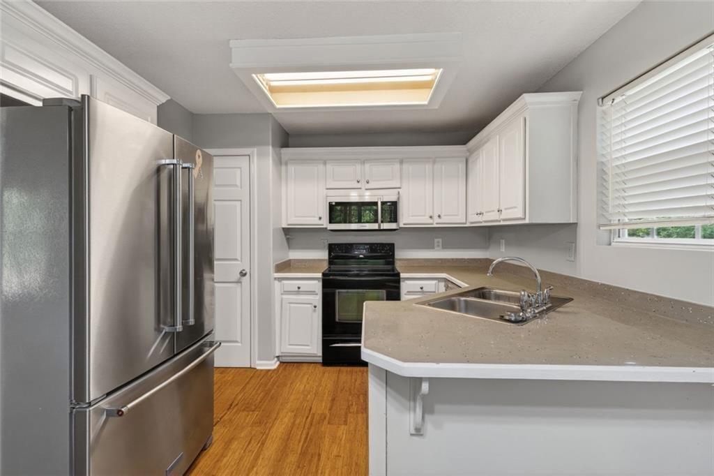 466 Raymond Drive Winder, GA 30680 - Photo 2 of 33 a kitchen with a refrigerator sink and cabinets