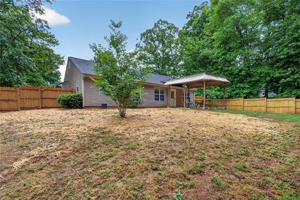 466 Raymond Drive Winder, GA 30680 - Photo 27 of 33 a backyard of a house with wooden fence