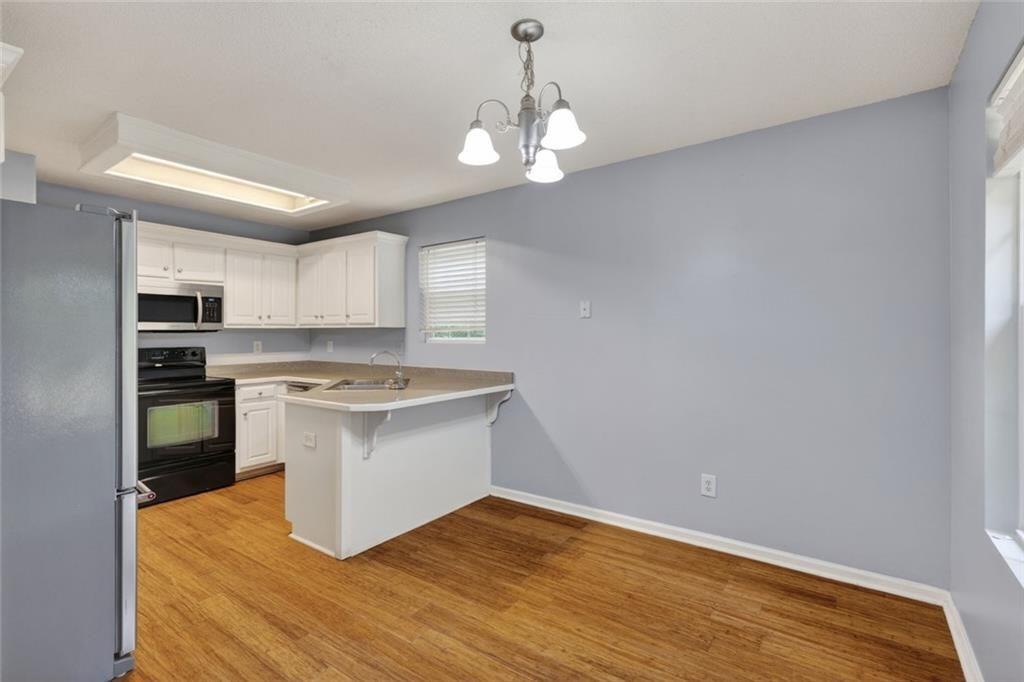 466 Raymond Drive Winder, GA 30680 - Photo 6 of 33 a kitchen with a sink stainless steel appliances and white cabinets