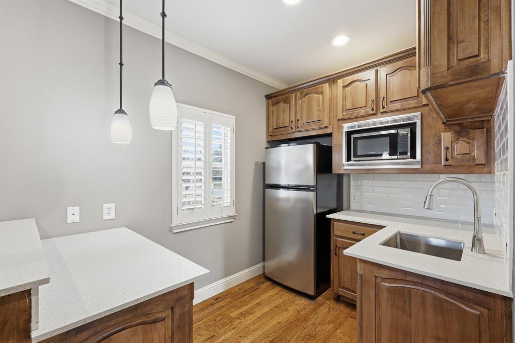 2201 Mockingbird Lane Flower Mound, TX 75022 - Photo 29 of 40 a kitchen with stainless steel appliances granite countertop a refrigerator a stove a sink dishwasher and wooden cabinets with wooden floor