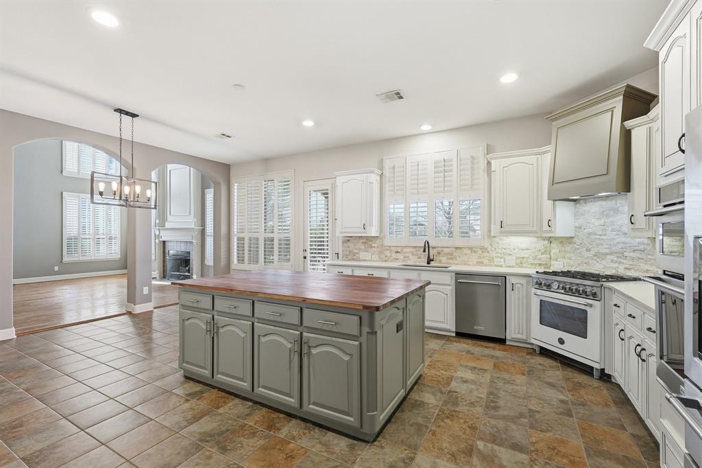 2201 Mockingbird Lane Flower Mound, TX 75022 - Photo 9 of 40 a large kitchen with stainless steel appliances granite countertop a stove and a sink