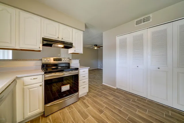 a kitchen with stainless steel appliances white cabinets and a stove top oven