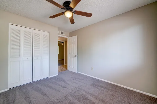 an empty room with a ceiling fan and a fan