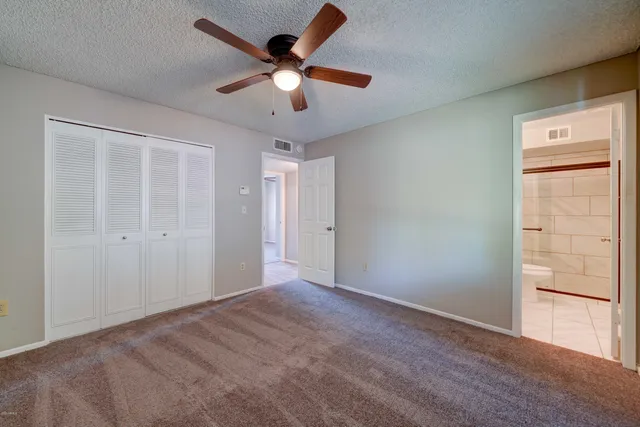 an empty room with closet and windows