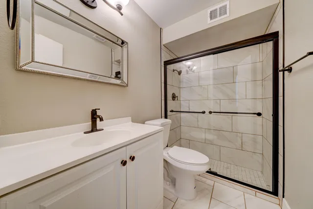 a bathroom with a sink a toilet and shower