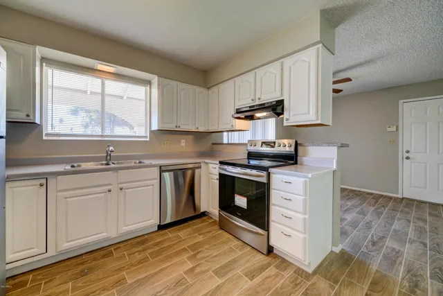 a kitchen with stainless steel appliances granite countertop a stove a sink and a microwave