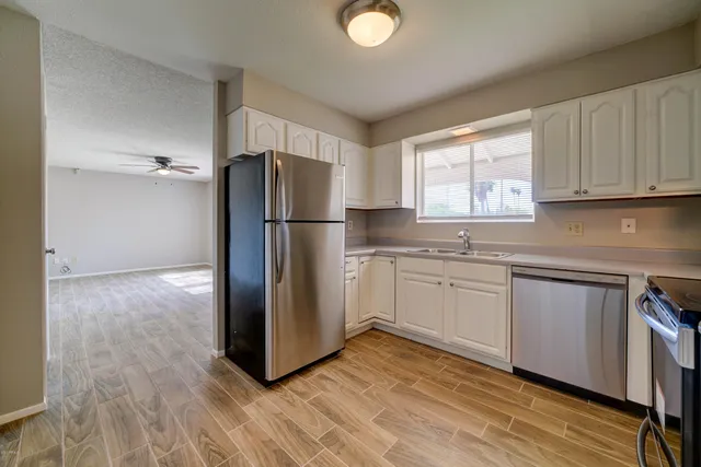 a kitchen with a refrigerator sink and cabinets