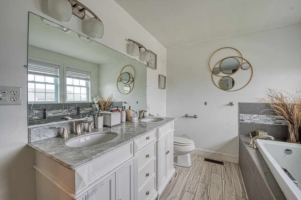 438 Smith Street Fall River, MA 02721 - Photo 24 of 31 a bathroom with a granite countertop sink mirror vanity and toilet
